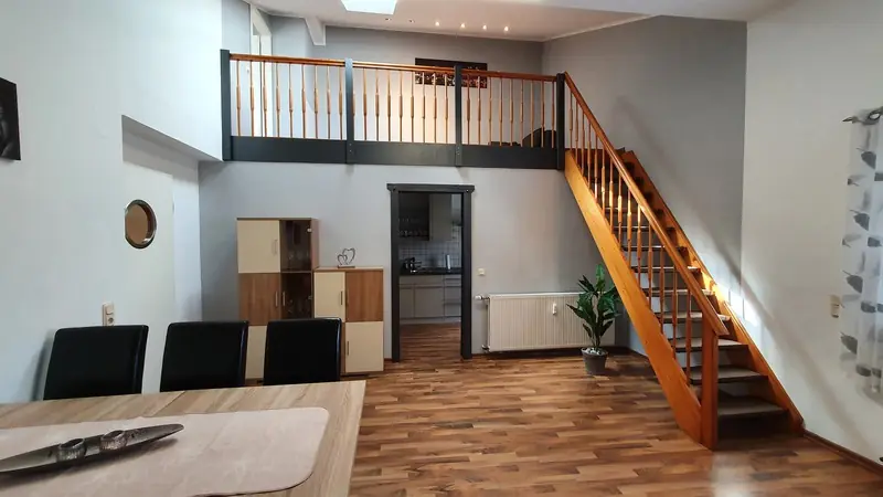 Ferienhaus: Essbereich mit Holztreppe zur offenen Galerie